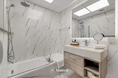 a white bathroom with a tub and a sink at Cozy 1BR Apartment in Dubai Marina with City Views in Dubai