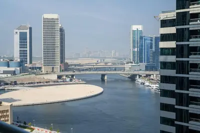 a bridge over a river in a city with buildings at Airstay - Cozy 1BR - Canal View - Business Bay - Monthly Offer Available in Dubai