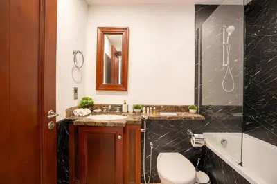 a bathroom with a toilet and a sink and a tub at Zaafaran 5 Full Burj View Downtown Luxury Stay in Dubai