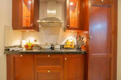 a kitchen with wooden cabinets and a counter top at Zaafaran 5 Full Burj View Downtown Luxury Stay in Dubai