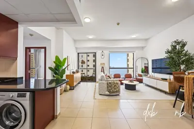 a living room with a washer and dryer at Pistachio Pecan - Sea View - Luxury 1 BR Apartment at JBR Beach in Dubai