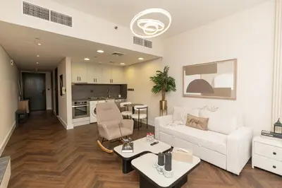 a living room with a white couch and a table at JLT Laguna Tower Spacious Studio with Lake View for 4 Guests in Dubai