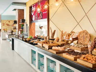 a baker in a bakery with bread and pastries at JLT Laguna Tower Spacious Studio with Lake View for 4 Guests in Dubai