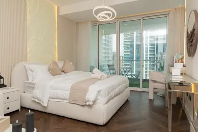 a bedroom with a white bed and a view of a city at JLT Laguna Tower Spacious Studio with Lake View for 4 Guests in Dubai