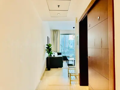 a hallway with a living room with a couch and a chair at Modern Apartment standpoint near dubai opera in Dubai