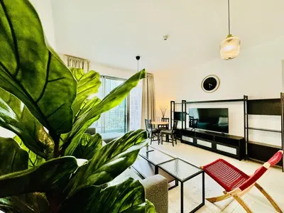 a living room with a potted plant and a tv at Modern Apartment standpoint near dubai opera in Dubai