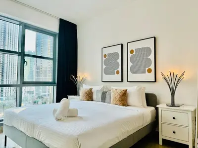 a bedroom with a large white bed and a window at Modern Apartment standpoint near dubai opera in Dubai