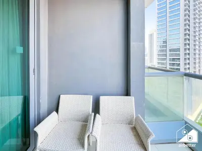 two chairs on a balcony with a view of a city at Elegant 2-Bed Retreat, Stunning Downtown Views in Dubai