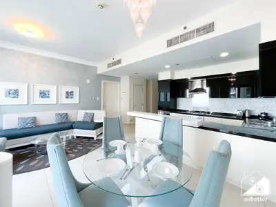 a kitchen and living room with a glass table and chairs at Elegant 2-Bed Retreat, Stunning Downtown Views in Dubai