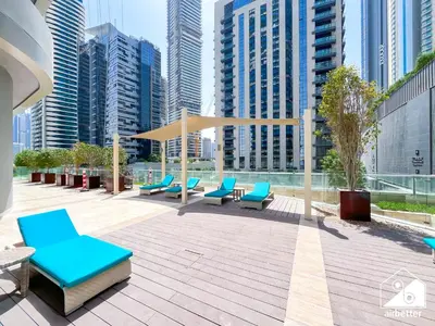 a patio with blue chairs and tables and buildings at Elegant 2-Bed Retreat, Stunning Downtown Views in Dubai