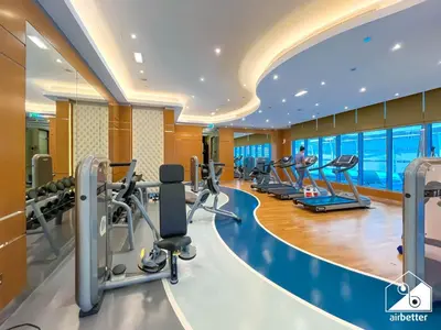 a gym with cardio equipment and a swimming pool at Elegant 2-Bed Retreat, Stunning Downtown Views in Dubai