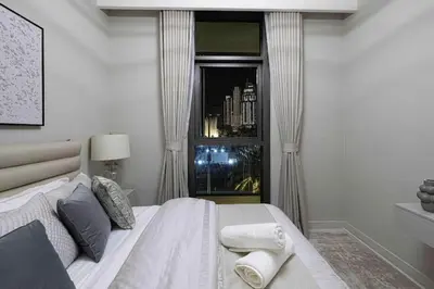 a bedroom with a large white bed and a window at Luxury Apartment - Downtown in Dubai