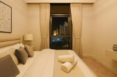 a bedroom with a large white bed with a window at Luxury Apartment - Downtown in Dubai