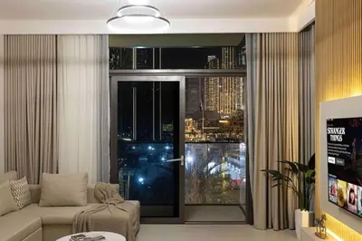 a living room with a couch and a large window at Luxury Apartment - Downtown in Dubai