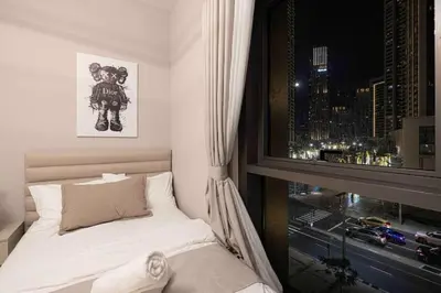 a small bedroom with a bed and a window at Luxury Apartment - Downtown in Dubai