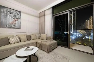 a living room with a couch and a large window at Luxury Apartment - Downtown in Dubai