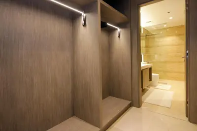 a bathroom with a wooden wall with a toilet at Luxury 1BR at Sterling East , Burj Khalifa Views in Dubai