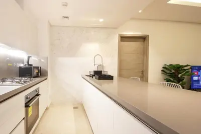 a kitchen with white cabinets and a counter top at Luxury 1BR at Sterling East , Burj Khalifa Views in Dubai