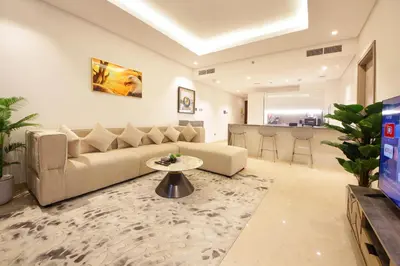 a living room with a couch and a table at Luxury 1BR at Sterling East , Burj Khalifa Views in Dubai