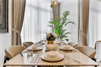 a dining room table with chairs and a teddy bear on top at Deluxe, Elegant - 3BR - DT - Burj Khalifa View in Dubai