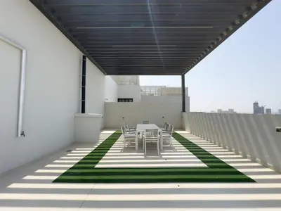 a patio with a table and chairs on a roof at New Studio Aura JVC Pool Gym Sauna Padel court in Dubai