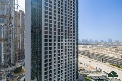 a tall white building in a city with buildings at Cozy 1BR for 3 with Community View by BMS in Dubai