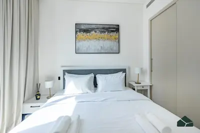 a bedroom with a large white bed with white pillows at Cozy 1BR for 3 with Community View by BMS in Dubai