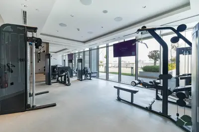 a gym with treadmills and ellipticals in a building at Cozy 1BR for 3 with Community View by BMS in Dubai