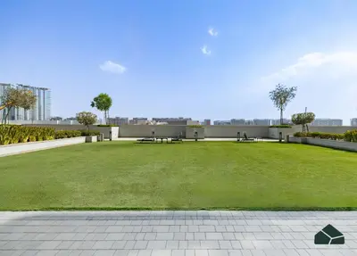 a park with benches and grass on a building at Cozy 1BR for 3 with Community View by BMS in Dubai