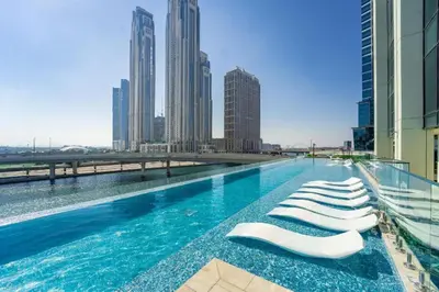 a swimming pool with lounge chairs on the roof of a building at Infinity Pool - 6 minutes to Dubai Mall - Luxury in Dubai