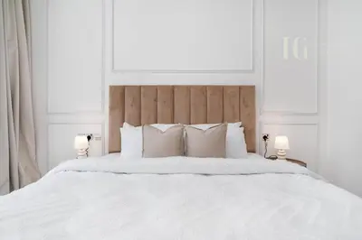 a bed with white sheets and pillows in a bedroom at Stylish Living with a Cozy Touch in Dubai
