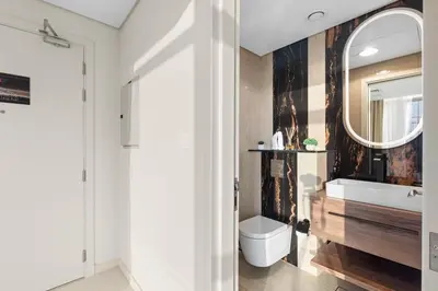 a bathroom with a sink and a toilet and a mirror at Luxe High-Rise with Burj Khalifa and Sunset view in Dubai