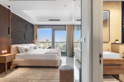 a bedroom with a bed and a tub and a sink at Luxe High-Rise with Burj Khalifa and Sunset view in Dubai