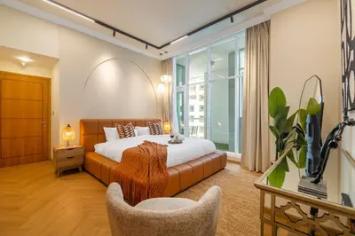 a bedroom with a bed and a couch and a window at SkyHigh 4BR Penthouse Marina Views & Game Lounge Pool Table PS5 in Dubai