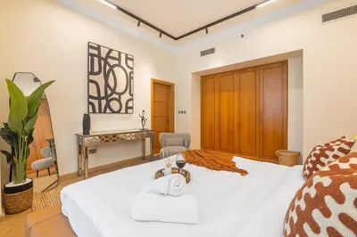 a bedroom with a white bed and a piano at SkyHigh 4BR Penthouse Marina Views & Game Lounge Pool Table PS5 in Dubai