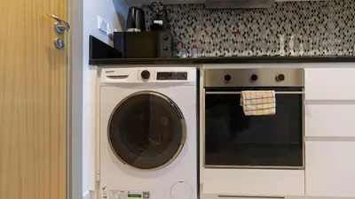 a kitchen with a washing machine and a counter at Charming Studio with Cozy Vibes in Dubai