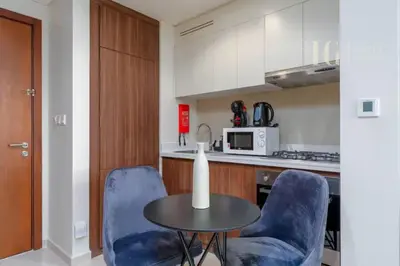 a kitchen with a table and two blue chairs at Luxury Apartment in the Heart of the City in Dubai
