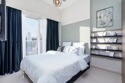 a white bedroom with a bed and a window at Luxury Apartment in the Heart of the City in Dubai