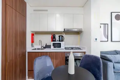 a kitchen and living room with a table and chairs at Modern Comfort in Business Bay in Dubai
