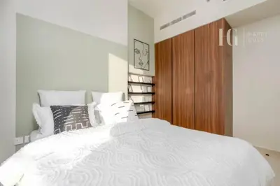 a bedroom with a white bed and a wooden cabinet at Modern Comfort in Business Bay in Dubai