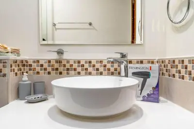a bathroom with a large white sink and a mirror at Modern Comfort in Business Bay in Dubai