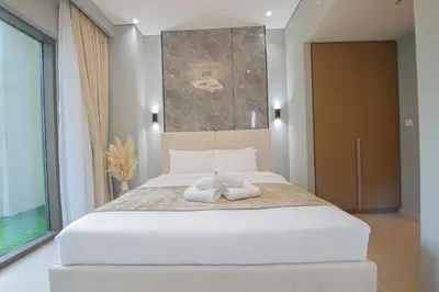 a bedroom with a large bed with two towels on it at Rosewater at Creek Beach Building 2 Luxury Creekside Living with Beach & Pool Access in Dubai