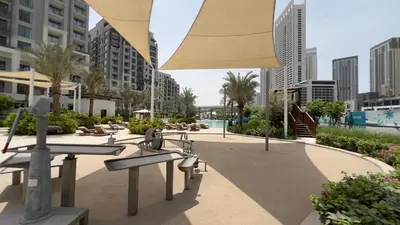 a resort with a pool and chairs and an umbrella at Rosewater at Creek Beach Building 2 Luxury Creekside Living with Beach & Pool Access in Dubai