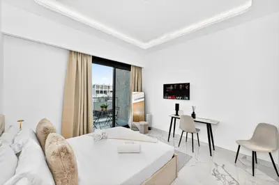 a white room with a bed and a table and chairs at Azizi Riviera Gateway - Highest Floor Superior Apartment in Dubai