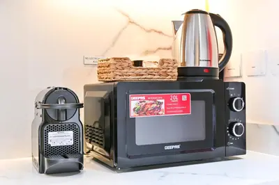 a microwave with a coffee pot on top of it at Azizi Riviera Gateway - Highest Floor Superior Apartment in Dubai