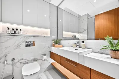a white bathroom with a sink and a toilet at Azizi Riviera Gateway - Highest Floor Superior Apartment in Dubai
