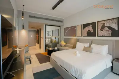 a bedroom with a large white bed and a living room at Magnificent living at Downtown in Dubai