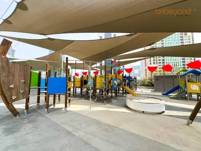 a play area with a playground with an umbrella at Magnificent living at Downtown in Dubai