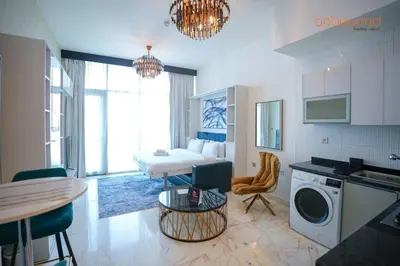 a kitchen and living room with a bed and a table at Bnbeyond Contemporary Living in Business Bay in Dubai