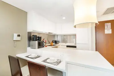 a kitchen with white cabinets and a white counter top at PVH - Emaar Fashion Avenue - 1BR Dubai Mall Access in Dubai